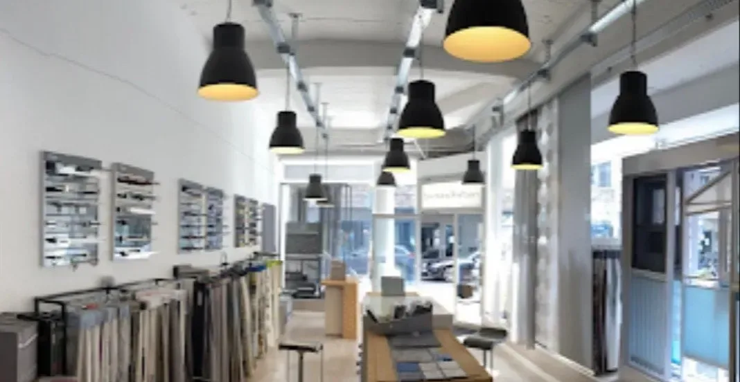 Ausstellung von Fensterkleider Köln an der Hohen Pforte: Stoffbücher, Musterwände und Schienensysteme unter schwarzen Pendelleuchten