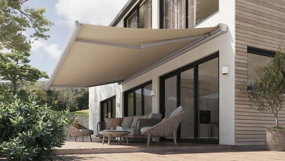 Ausgefahrene beige Gelenkarmmarkise über einer Holzterrasse mit Rattan-Loungemöbeln